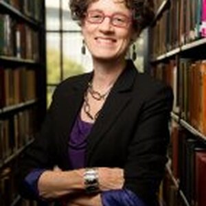 Professor Leslie Reagan, standing in her office. 2 book-cases in the background 